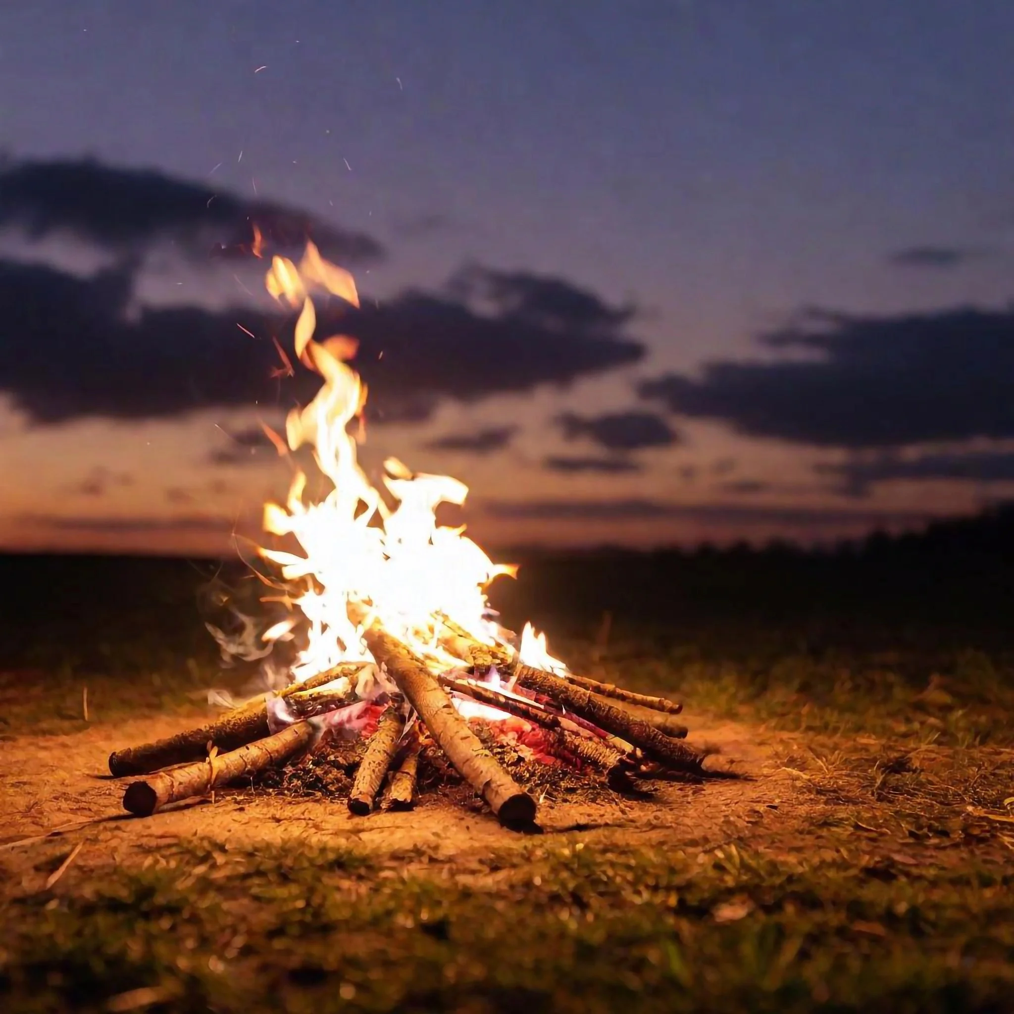 Campfire burning at dusk at an outdoor campsite